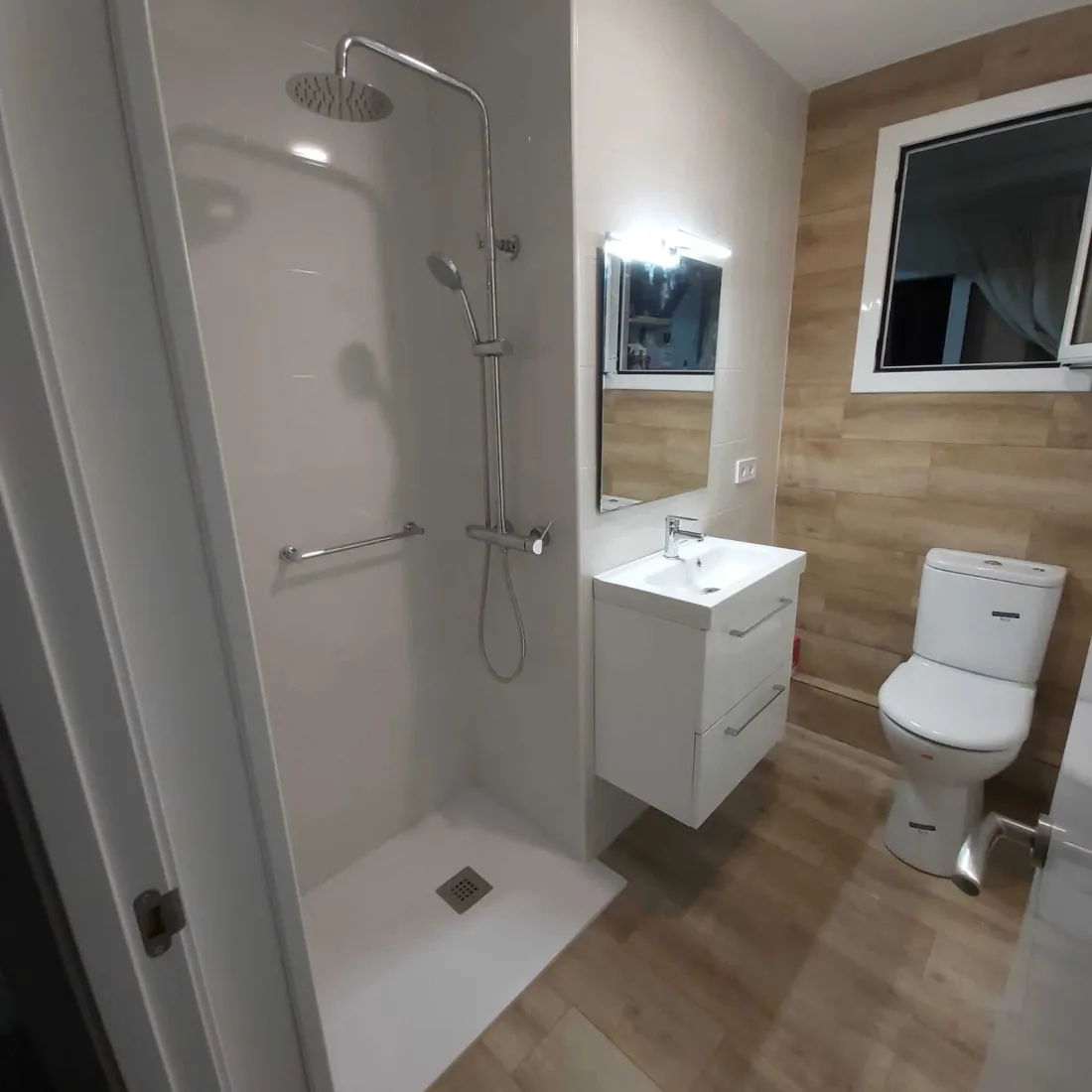 Bano reformado en Sabadell — bano moderno con plato de ducha y mampara de cristal